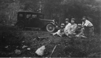 Members of the Mann family sit in the woods near Pecos, NM