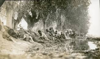 Revolutionary soldiers lie on the bank of a stream