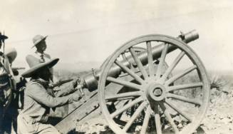 Several soldiers stand around the artillery gun at the Battle of Parral