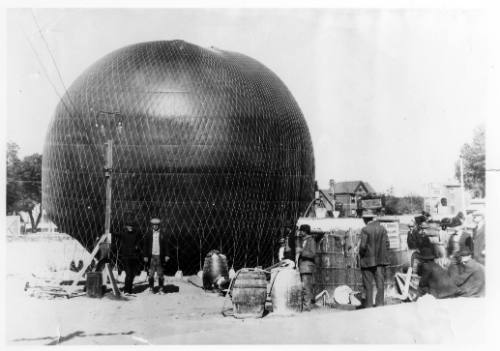 Joe Blondin and Roy Stamm stand in front of an inflating balloon