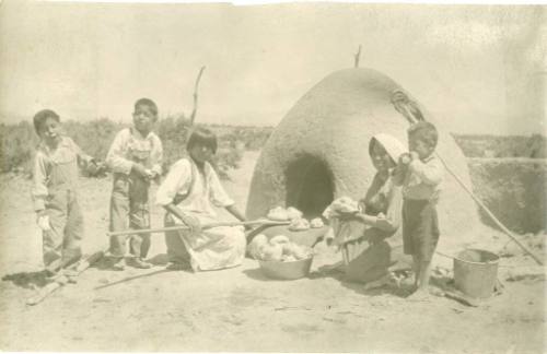 Pueblo women and children using an horno