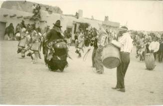 Native men performing a dance before a crowd