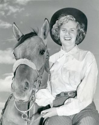 Pat Moen, State Fair Queen candidate, seated beside a horse