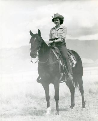 Betty Jo Smith sits atop a black horse named "Jimmy"