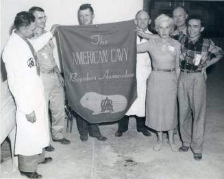 Members of the American Cavy Breeders Association stand with a banner