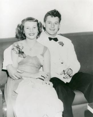 Deanie Ewing and Ronald Dean sit on a couch, in formal attire for a dance.
