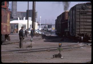 Railroad workers and boxcars in the railyards