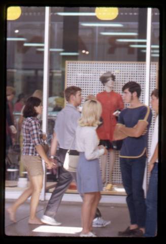Teenagers stand in front of a shop window on Central Avenue