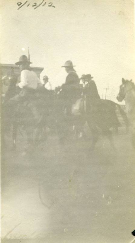 Five men on horseback ride into town