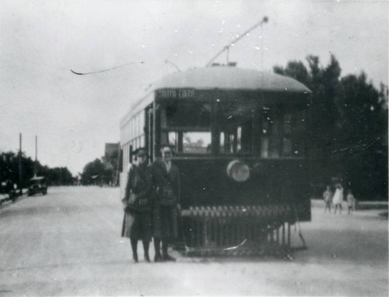 Elsie Westerfeld and an unidentified motorette stand in front of a trolley