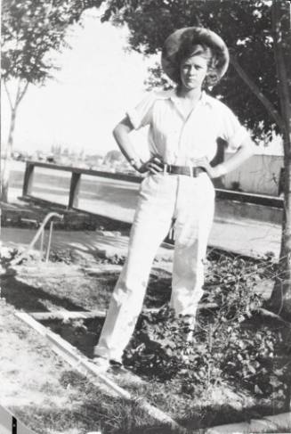 Grace Miller-Redd stands in the front yard of her home
