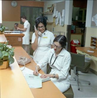 Two women work at a desk at Presbyterian Hospital