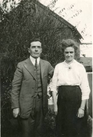 A Man and Woman in Front of a Wooden Building