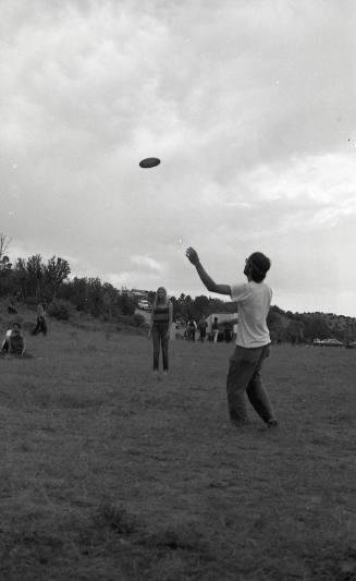 A man and woman play frisbee