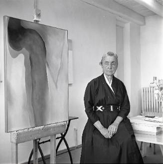Georgia O'Keeffe seated with painting #9-A