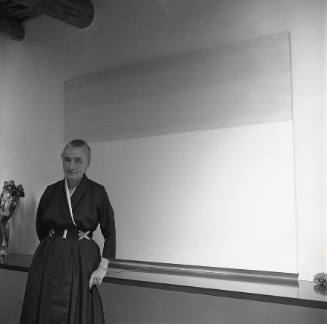 Georgia O'Keeffe standing at painting