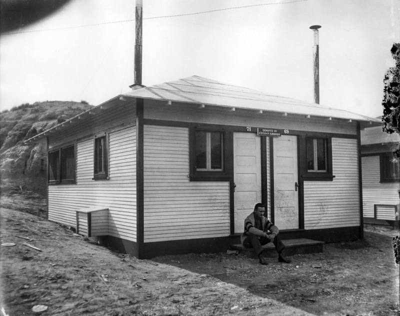 Patient sits outside a cottage at a sanatorium