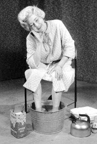 Woman Soaking feet in Water and Epsom Salt