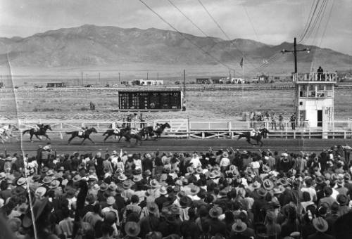 Horse race finishing at the State Fairgrounds racetrack, a large crowd watching
