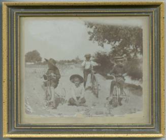 Four boys beside an acequia