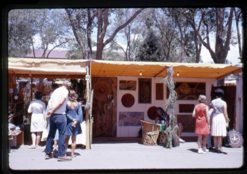 Shoppers look in artist booths at an arts & crafts fair in Old Town
