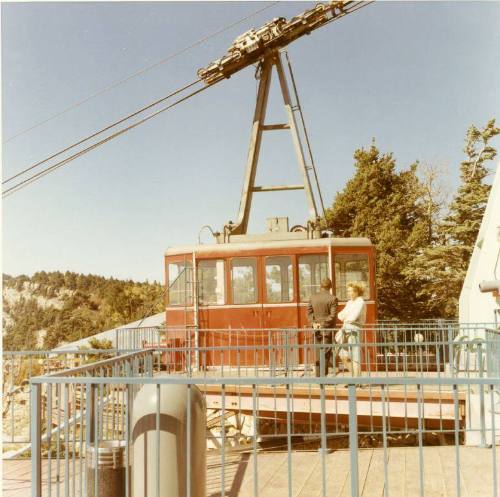 Two people stand on the loading platform for the Sandia Peak Tramway