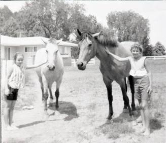 Becky McBeth and Lori Dean stand with two horses