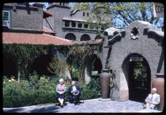 Three people sit in a patio at the Alvarado Hotel