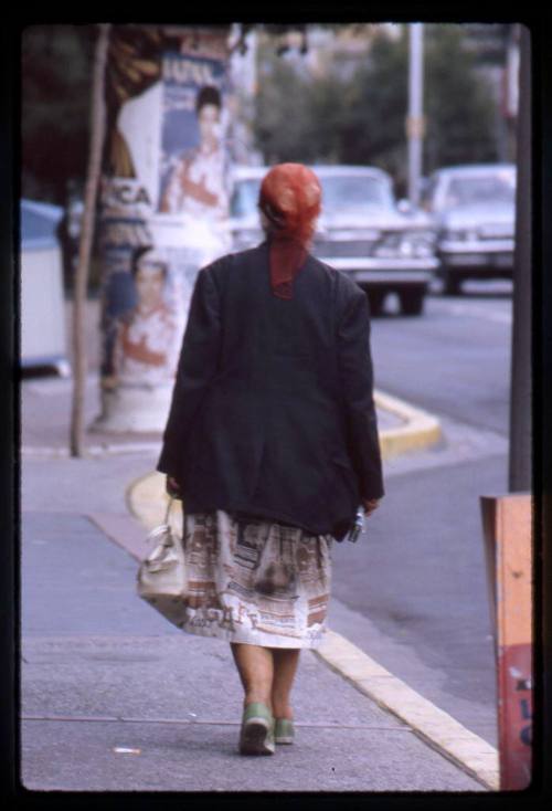 A woman walks down the sidewalk
