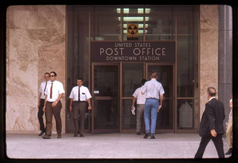 Men enter and exit the United States Post Office
