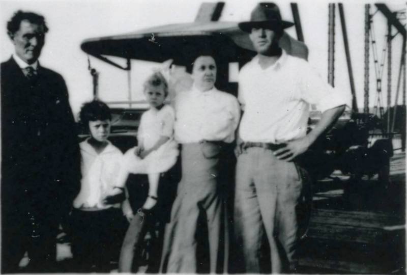 The Miller family stands beside a car on a bridge over the Rio Grande