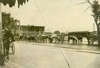 Horse-drawn wagons parked along a street