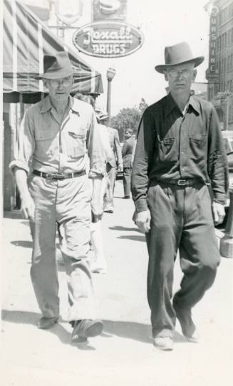 Two men walking down a Central Avenue sidewalk