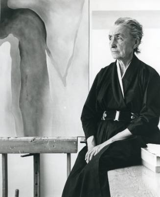 Georgia O'Keeffe seated with painting #13-A