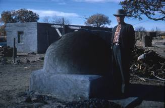 Dr. Frank Bowdish standing next to adobe oven